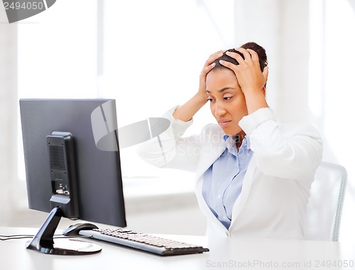 Image of stressed african woman with computer