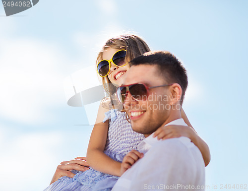 Image of happy father and child in sunglasses over blue sky