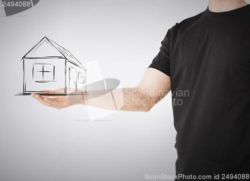 Image of house on virtual screen in man hand