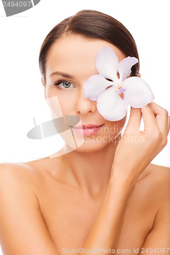 Image of relaxed woman with or??hid flower over eye