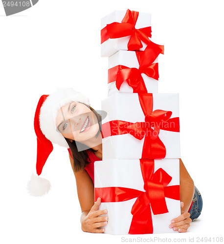 Image of smiling woman in santa helper hat with gift boxes
