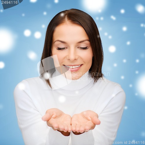 Image of woman in winter clothes with something on palms