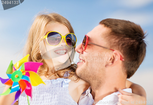 Image of happy father and child in sunglasses over blue sky