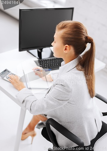 Image of businesswoman with notebook and calculator