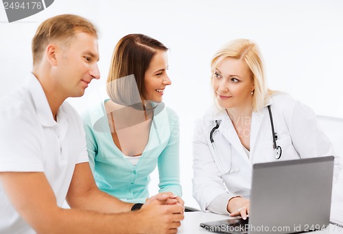 Image of doctor with patients looking at laptop