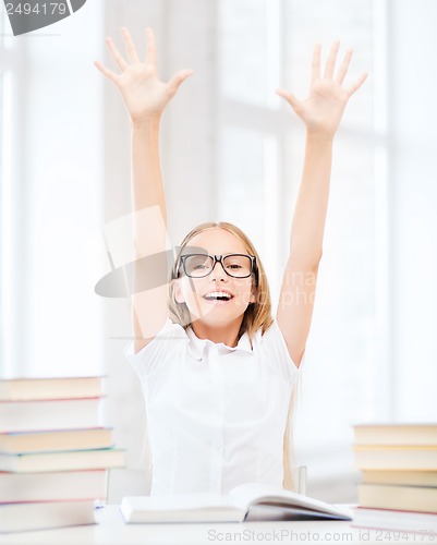 Image of girl with books and hands up