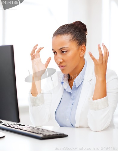Image of stressed african woman with computer