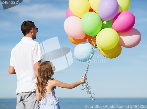 Image of father and daughter with colorful balloons
