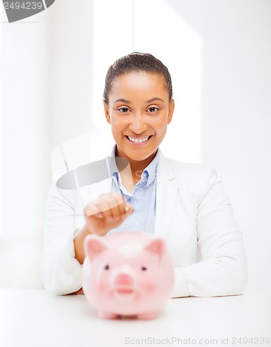 Image of woman with piggy bank and coin