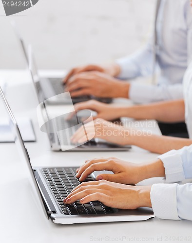 Image of group of people working with laptops in office