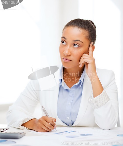 Image of businesswoman working with calculator in office