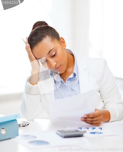 Image of businesswoman working with calculator in office