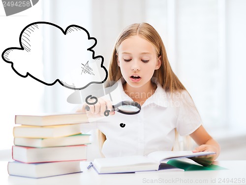 Image of girl reading book with magnifier at school