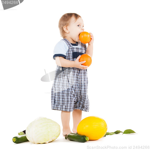 Image of toddler with vegetables eating orange