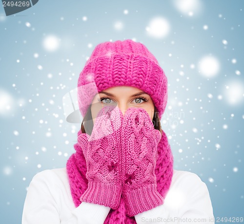 Image of surprised woman in hat, muffler and mittens