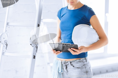 Image of woman architect with helmet and blueprint