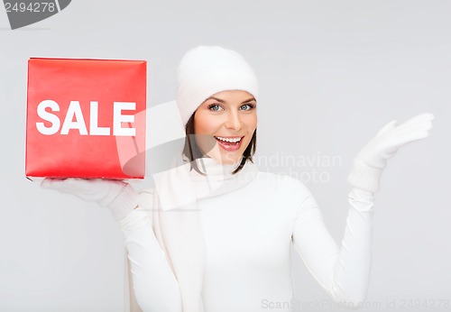 Image of woman in winter clothes with red sale sign