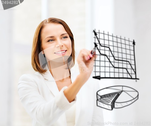 Image of businesswoman drawing charts in the air