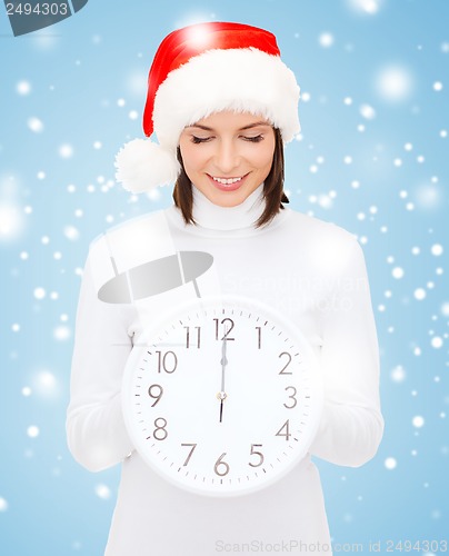 Image of woman in santa helper hat with clock showing 12