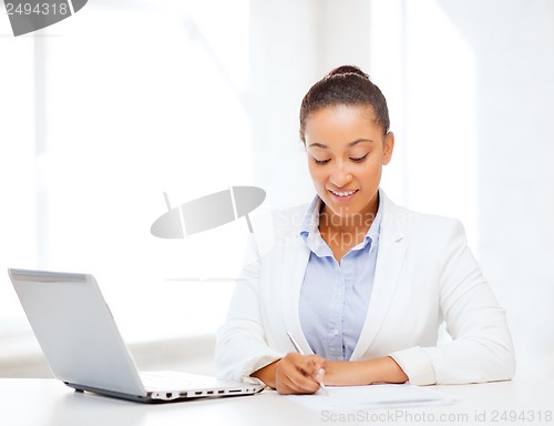 Image of african businesswoman writing something