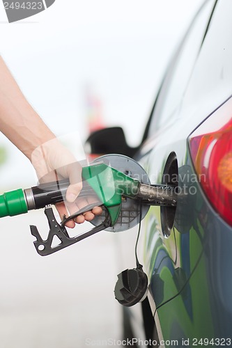 Image of man pumping gasoline fuel in car at gas station