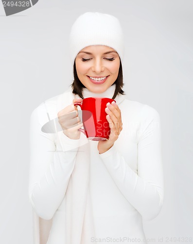 Image of woman in hat with red tea or coffee mug