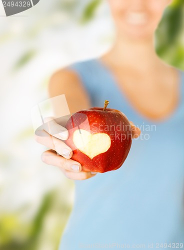 Image of woman hand holding red apple with heart shape