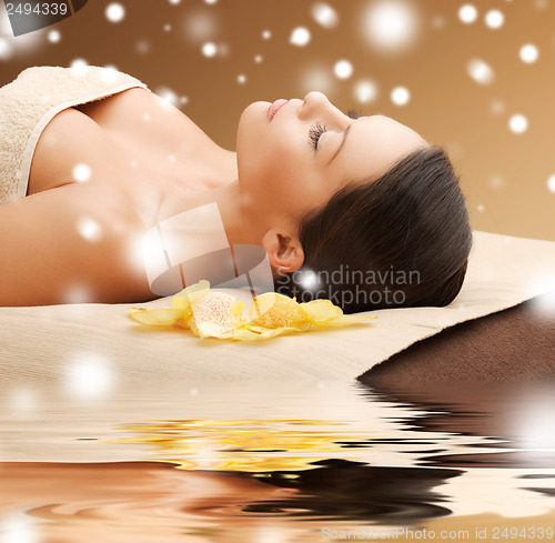 Image of woman in spa salon lying on the massage desk