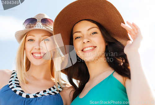 Image of girls in hats on the beach