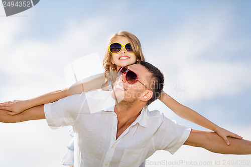 Image of happy father and child in sunglasses over blue sky