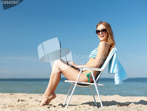 Image of girl looking at tablet pc on the beach