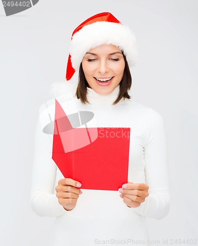 Image of woman in santa helper hat with blank red postcard