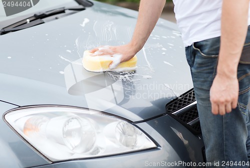 Image of man washing a car