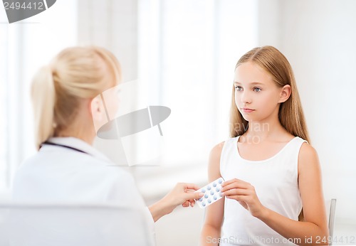 Image of doctor giving tablets to child in hospital