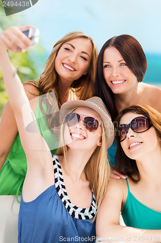 Image of girls taking photo in cafe on the beach