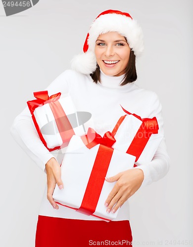 Image of woman in santa helper hat with many gift boxes