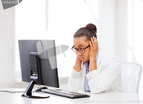 Image of stressed african woman with computer