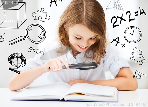 Image of girl reading book with magnifier at school