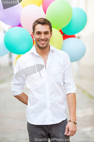 Image of man with colorful balloons in the city