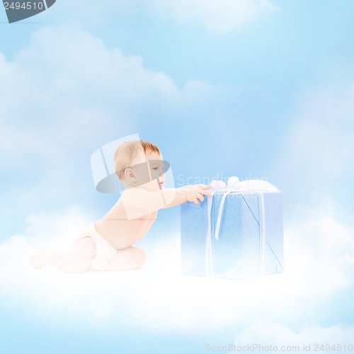 Image of smiling baby with present on the cloud