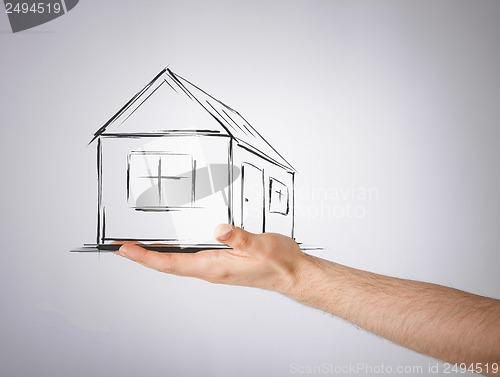 Image of house on virtual screen in man hand