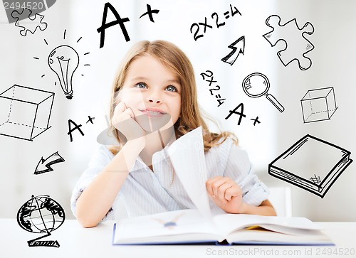 Image of little student girl studying at school