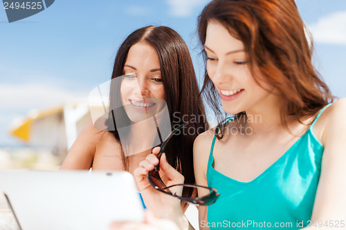 Image of girls looking at tablet pc in cafe