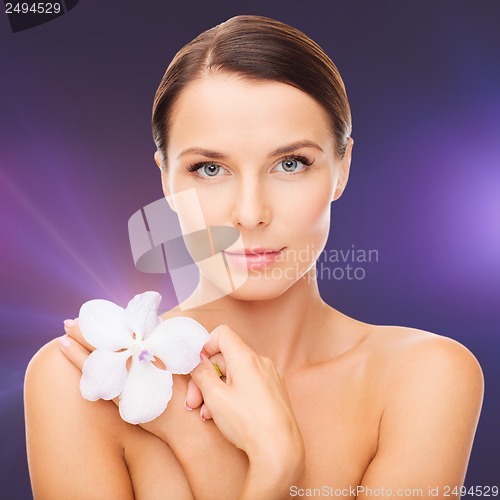 Image of relaxed woman with orhid flower