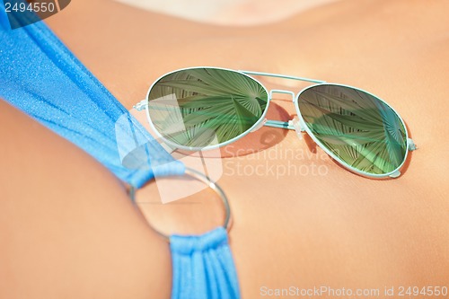 Image of sunglasses laying on woman body