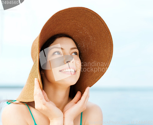Image of girl in hat standing on the beach