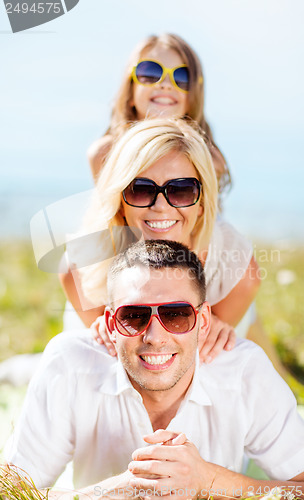 Image of happy family with blue sky and green grass