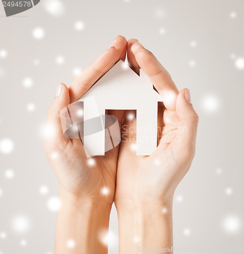 Image of woman hands holding paper house
