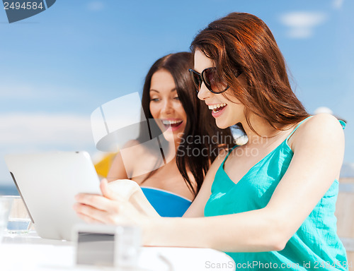 Image of girls looking at tablet pc in cafe