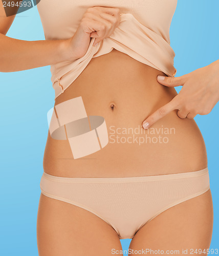 Image of woman pointing at her abs